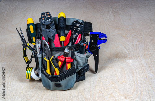 Electrician's bag with a professional electric tools. Place fot text. photo