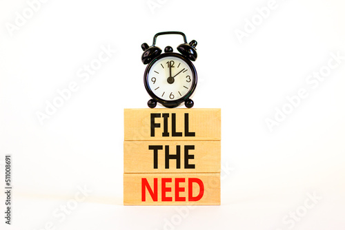 Fill the need symbol. Concept words Fill the need on wooden blocks on a beautiful white table white background. Black alarm clock. Business, finacial and fill the need concept. Copy space.