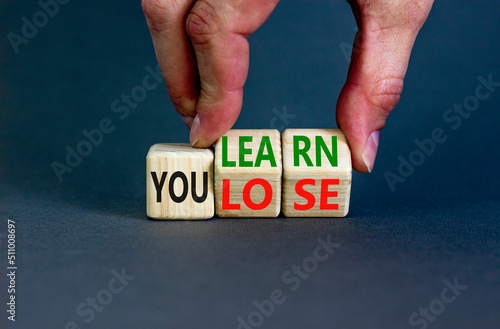 We learn or lose symbol. Concept words We learn and We lose on wooden cubes. Businessman hand. Beautiful grey table grey background. Business and we learn or lose concept. Copy space.