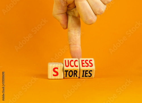 Success stories symbol. Concept words Success stories on wooden cubes. Businessman hand. Beautiful orange table orange background. Business and Success stories concept. Copy space.