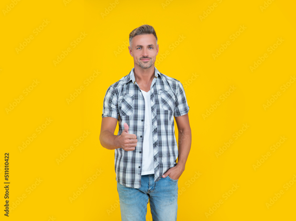 mature man with grizzle hair on yellow background. thumb up mature man with grizzle hair on yellow background. thumb up