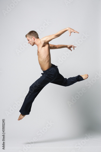 modern ballet male dancer posing over white studio background