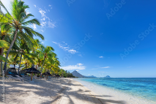 Paradise beach resort with palm trees and and tropical sea in Mauritius island. Summer vacation and tropical beach concept. © lucky-photo