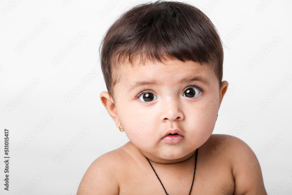 Indian baby girl playing on white background.
