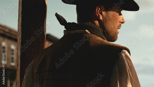 Fotografie, Tablou Cowboy entering the wild west city, CU on gun and holster