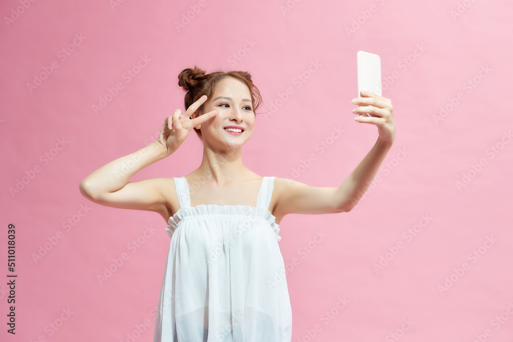 Photo of young beautiful smiling good mood take selfie show v-sign wear jumper on shoulders isolated on pink background Photo of young beautiful smiling good mood take selfie show v-sign wear jumper on shoulders isolated on pink background