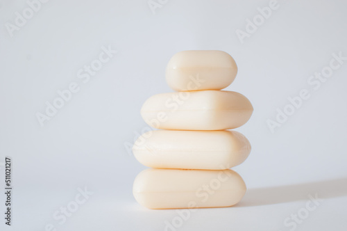 Vertical stack of white soap bars isolated on white background with selective focus. Hypoallergenic, without dyes and perfumes.