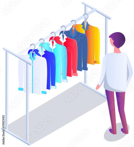 Man choosing clothes varicoloured shirts hanging on hangers, elements of wardrobe in store. Male shopper standing in front of hangers and looking at outfit. Fashion, clothes store, shopping concept