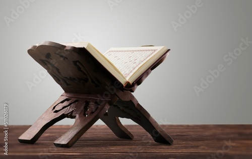 The Holy Al Quran with written Arabic calligraphy on a desk