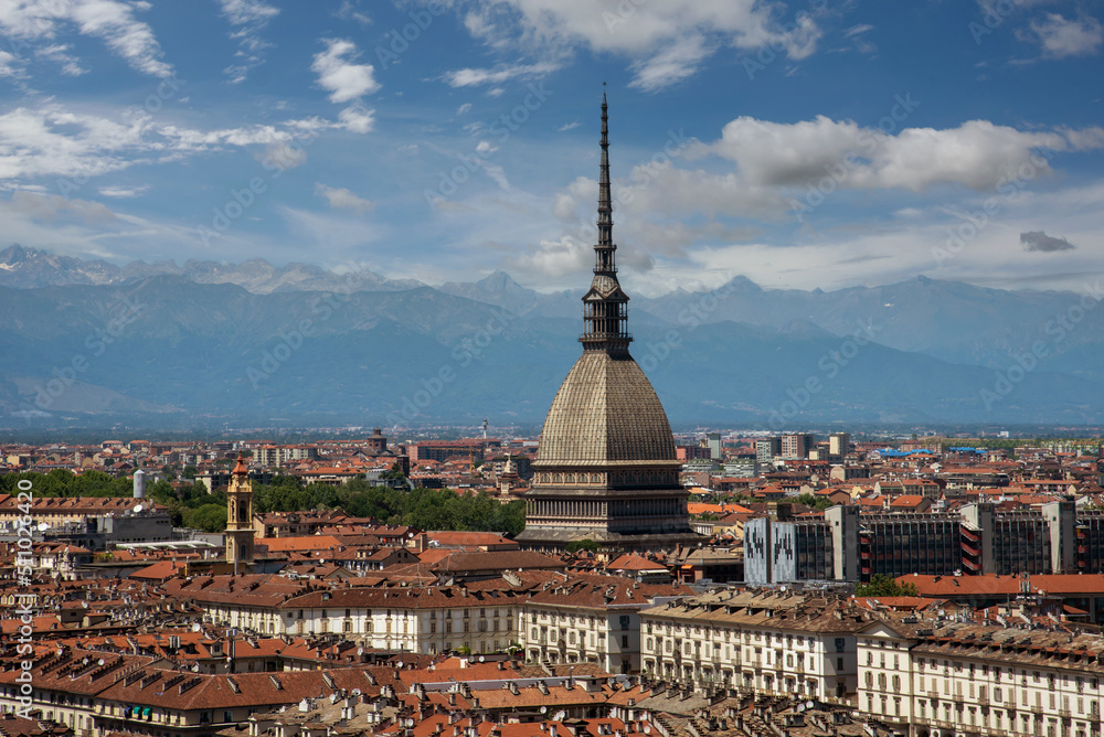 Turin, Piedmont, Italy - cityscape seen from above with the Mole Antonelliana architecture symbol of the city of Turin, in the background the Alps with blue sky with clouds