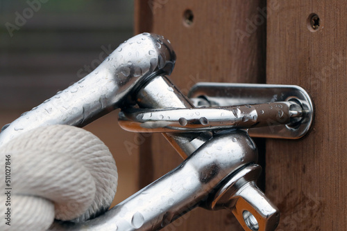 Obraz na plátně Shining stainless straght shackle with mooring rope tide up on the wood deck