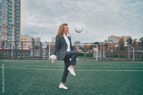 woman soccer player in an office suit stuffs the ball with her head. concept