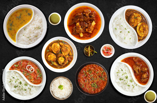 Fototapeta Naklejka Na Ścianę i Meble -  Assorted Indian Rice and curry dishes in one banner. Dal rice, Egg curry, Rajma chawal and mutton curry. Dark moody food banner for website or restaurant menu. Copy space. Dinner or lunch table.