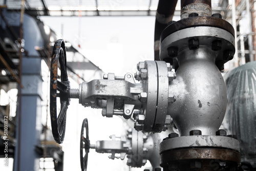Steel globe valve installed vertically on a steam pipe in a factory. Industrial equipment.