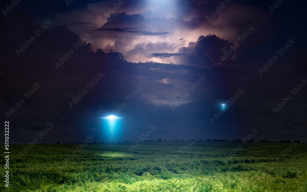 Scenic sci-fi image: UFO or alien spacecraft  inspect green grass field with bright spotlight in dark stormy night sky