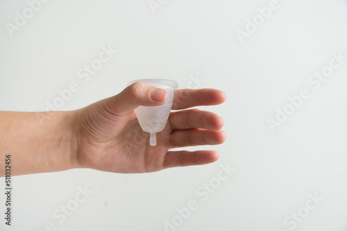 the woman holds a menstrual cup in her hands 
