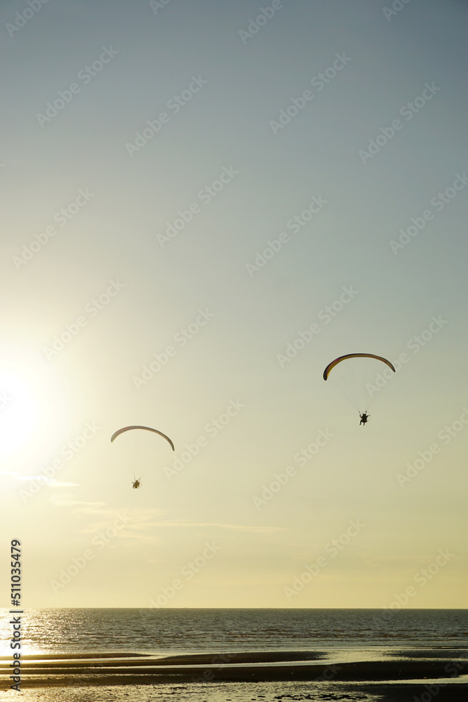 Silhouette of para gliding at sunset sky with sea background