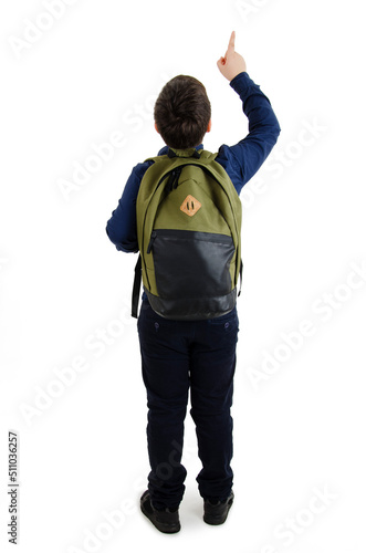 Back to school concept. Beautiful schoolboy with backpacks pointing at wall. Back view. Isolated on white background. Full length. Modern fashion teenage boy pointing on copy space
