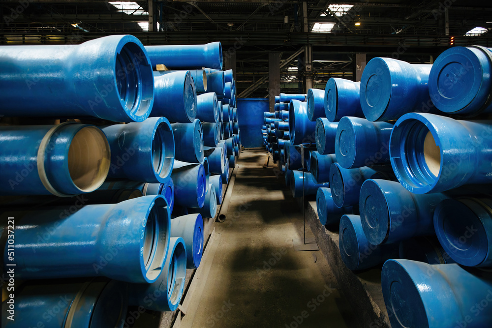 New blue colored cast iron pipes with caps for pipeline construction in