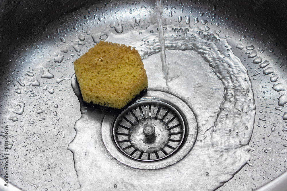 Water is pouring into the kitchen sink. Washing dishes. home plumbing Water is pouring into the kitchen sink. Washing dishes. home plumbing