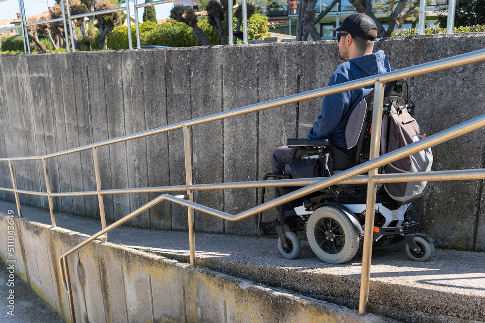 Man on a wheelchair use accessible ramp.