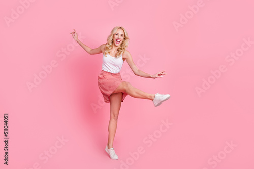 Full length body size view of attractive cheerful girl dancing having fun isolated over pink pastel color background