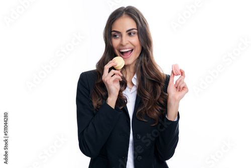 Charming woman want to bite tasty macaron, holding macaroon near open mouth, beauty girl enjoying sweets.