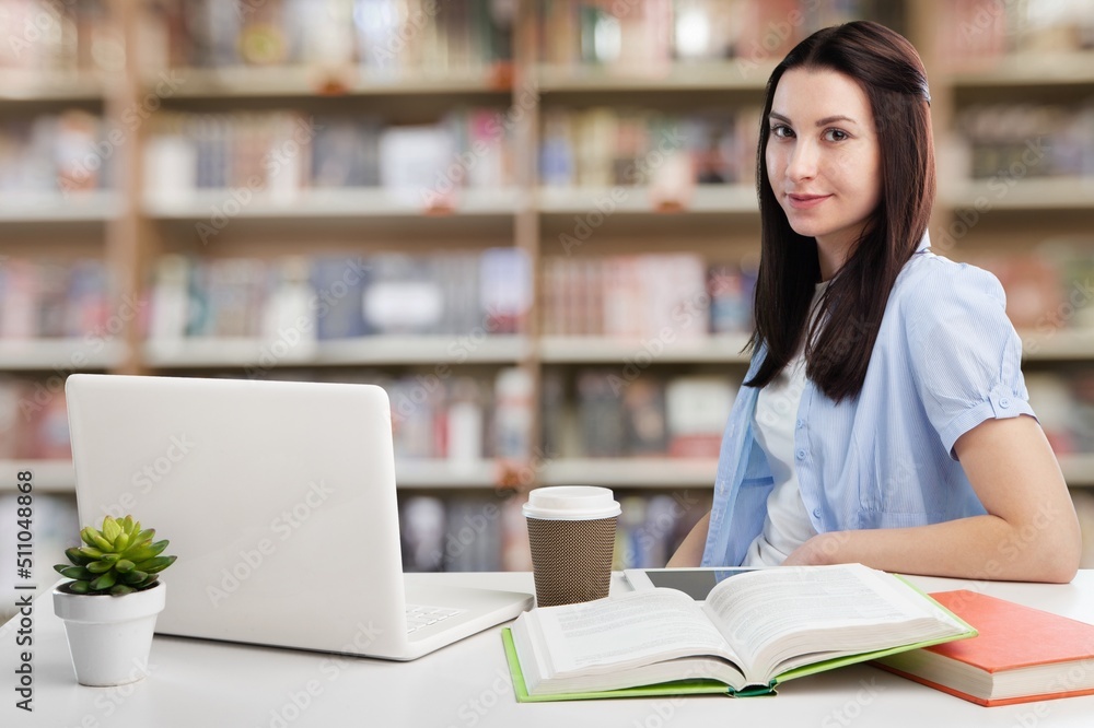Young student girl sit at table, studying alone in library, looks pensive and thoughtful search solution, prepare for exam, makes task feels confused or puzzled Young student girl sit at table, studying alone in library, looks pensive and thoughtful search solution, prepare for exam, makes task feels confused or puzzled