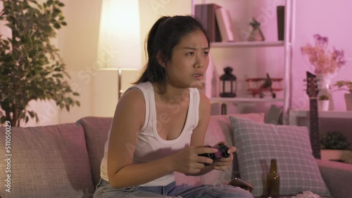 portrait of korean teenage girl hooked on video games. asian young lady holding wireless game controller is having a tough fight. unhealthy lifestyle and gaming disorder concept