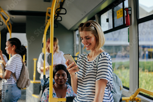 Young caucasian woman texting on city bus Fototapeta