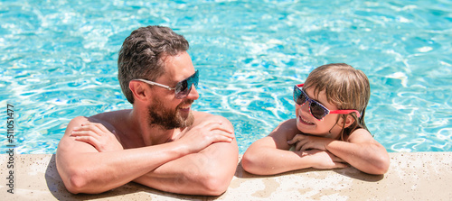 Father and son in swimming pool, banner with copy space. dad and child having fun at pool party. childhood and parenting. father and son