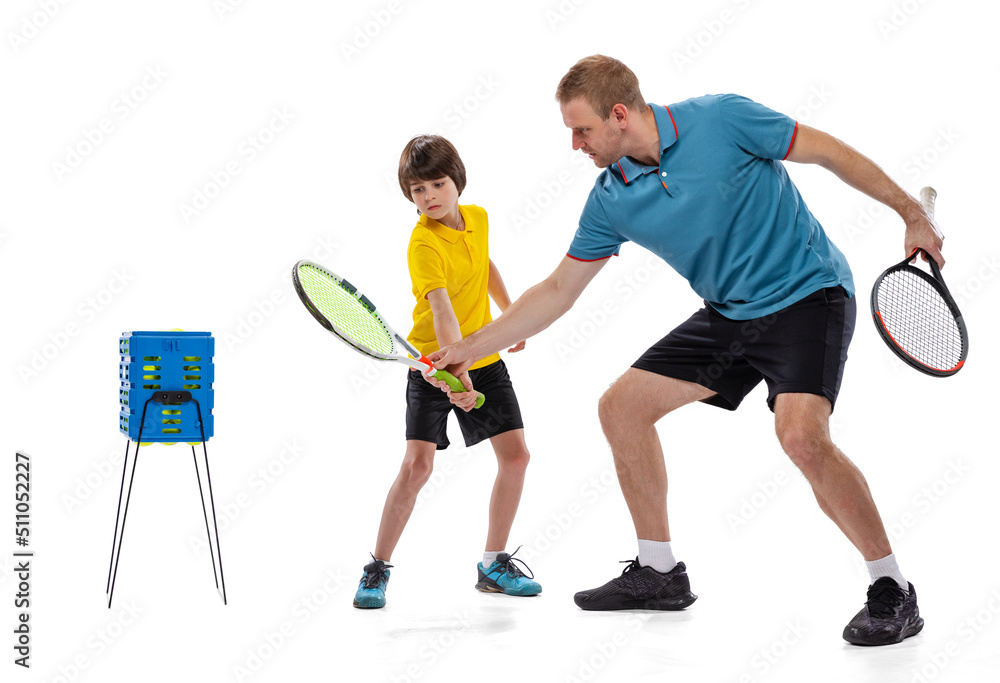 Professional tennis player, instructor and school age boy wearing sports uniform standing together isolated over white background. Concept of sport, achievements, hobby, skills