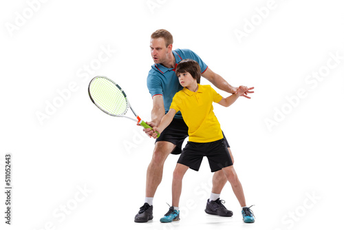 Male tennis player, coach training with teen to play tennis isolated over white studio background. Concept of sport, achievements, hobby, skills © master1305