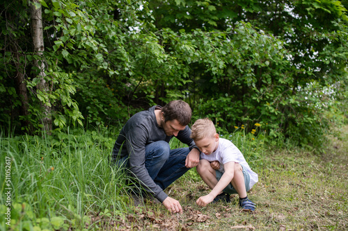 The boy is sitting next to his dad, looking at the ground © Julia Jones