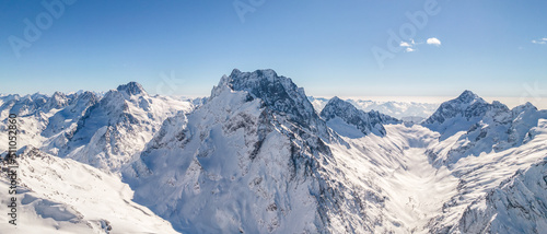 Shining peaks of the mountain range under the snow above the clouds  © SDF_QWE