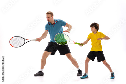 Tennis lesson. Professional tennis player, instructor shows basic techniques in game of tennis to school age boy. Concept of sport, achievements, hobby, skills