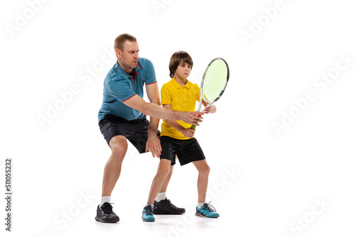 Training. Professional tennis player, coach teaches teen to play tennis isolated over white studio background. Concept of sport, achievements, hobby, skills