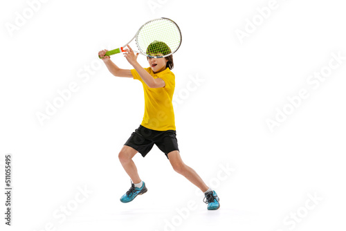 One sportive kid playing tennis isolated over white studio background. Concept of sport, achievements, hobby, skills