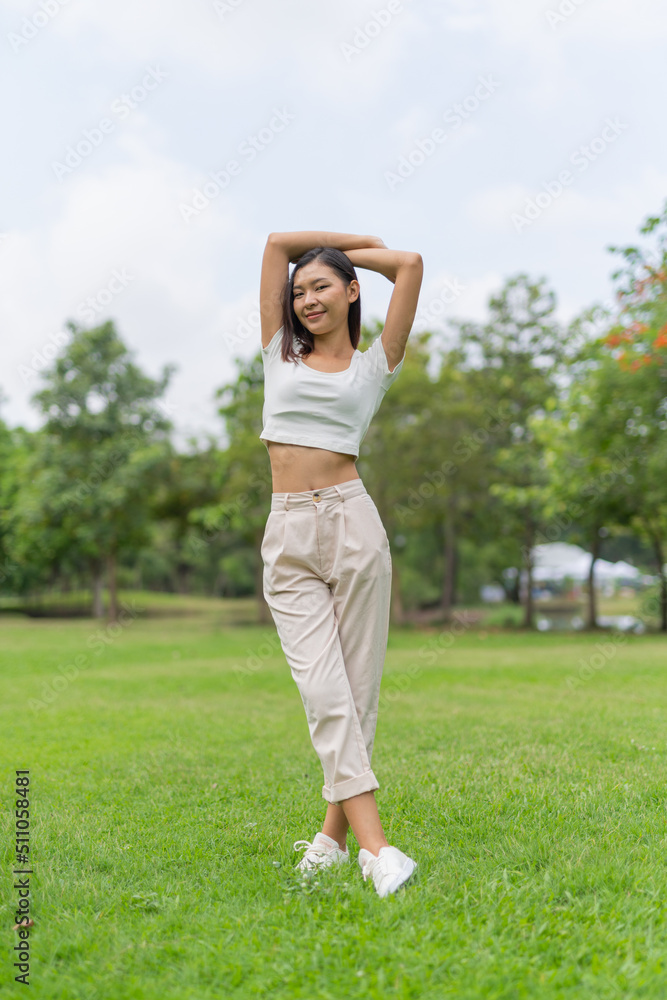 Portrait photo of a young beautiful asian female lady in white top embracing the breeze wind relaxingly and chillingly in a public park Portrait photo of a young beautiful asian female lady in white top embracing the breeze wind relaxingly and chillingly in a public park