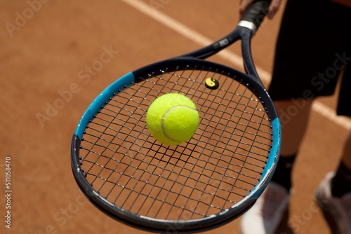Tennis yellow ball on a racket. Tennis. Sport. Ground courts. © LKoroleva