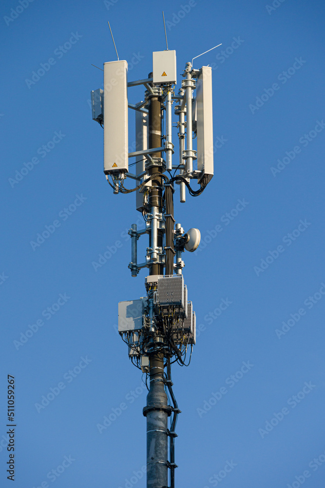 close-up of an antenna mast for mobile communications mounted at a roof top in front of blue sky 