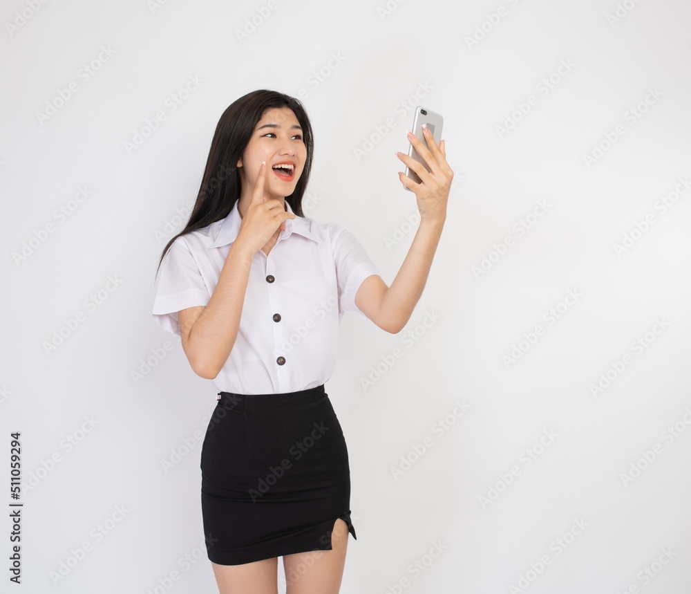 Portrait photo of a beautiful young asian female lady university student in happy mood video call and chat talking to her friend on a smartphone Portrait photo of a beautiful young asian female lady university student in happy mood video call and chat talking to her friend on a smartphone