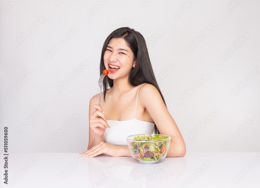 Portrait photo of a young beautiful asian female lady with a bowl of mixed salad in her hand. Good for healthy, fitness or dietary meal and restaurant advertisement or promotion. Portrait photo of a young beautiful asian female lady with a bowl of mixed salad in her hand. Good for healthy, fitness or dietary meal and restaurant advertisement or promotion.