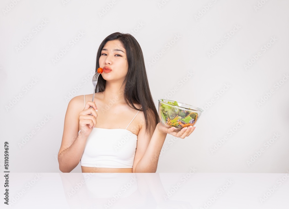 Portrait photo of a young beautiful asian female lady with a bowl of mixed salad in her hand. Good for healthy, fitness or dietary meal and restaurant advertisement or promotion. Portrait photo of a young beautiful asian female lady with a bowl of mixed salad in her hand. Good for healthy, fitness or dietary meal and restaurant advertisement or promotion.