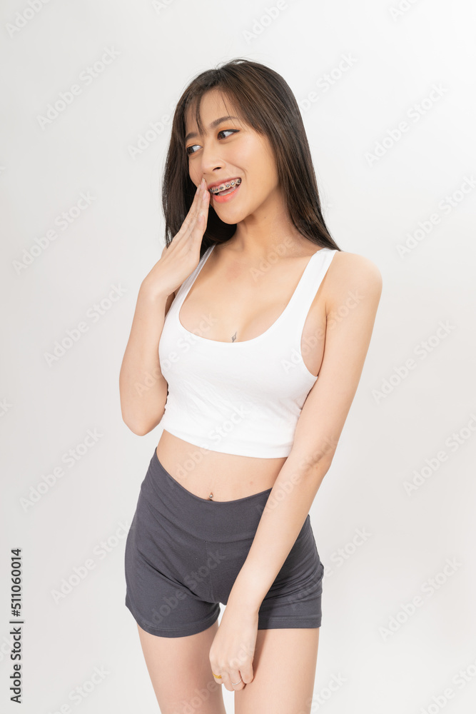 Portrait of a young and sexy beautiful asian female lady model with nice body shape wearing white tops and grey pants for indoor exercise Portrait of a young and sexy beautiful asian female lady model with nice body shape wearing white tops and grey pants for indoor exercise