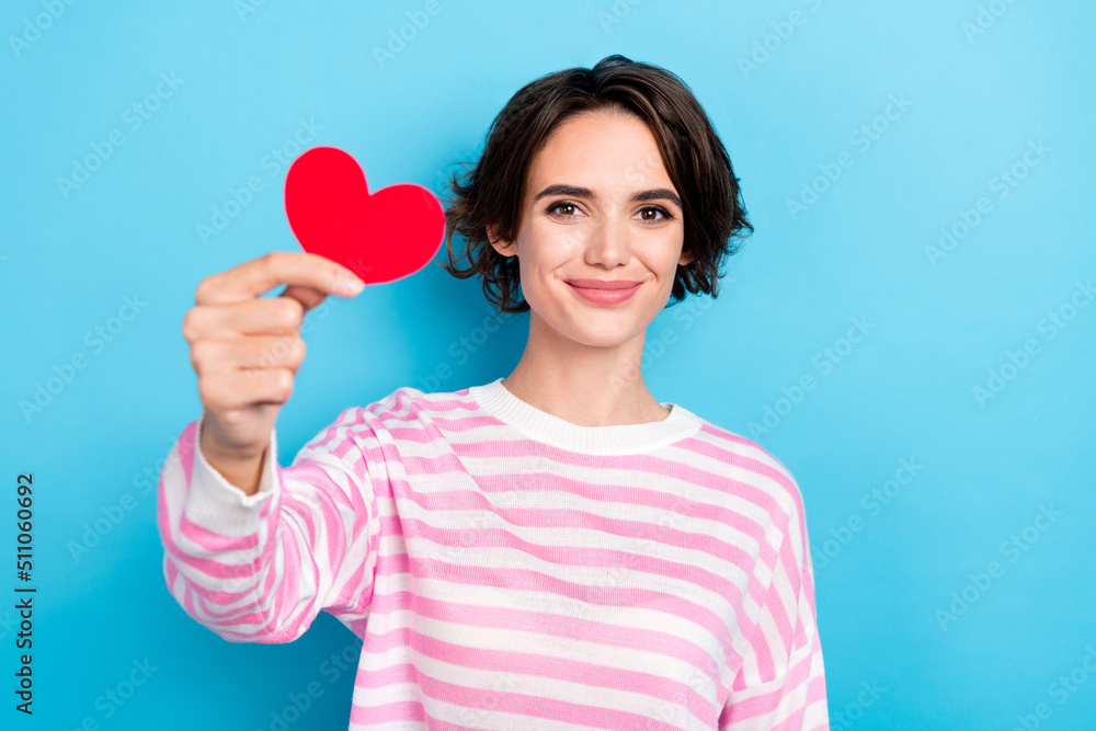 Portrait of pretty cheerful short haircut female give you little surprise red paper card isolated on blue color background Portrait of pretty cheerful short haircut female give you little surprise red paper card isolated on blue color background