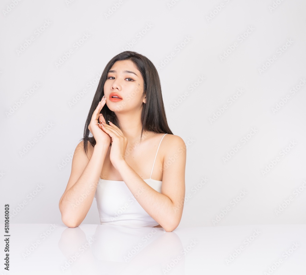 Portrait of a young, smart and very beautiful clean asian sexy female lady wearing white tank top with different elegant poses and emotions against a white studio background Portrait of a young, smart and very beautiful clean asian sexy female lady wearing white tank top with different elegant poses and emotions against a white studio background