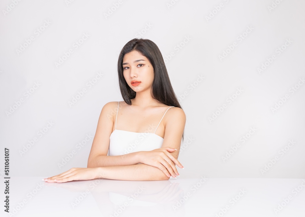 Portrait of a young, smart and very beautiful clean asian sexy female lady wearing white tank top with different elegant poses and emotions against a white studio background Portrait of a young, smart and very beautiful clean asian sexy female lady wearing white tank top with different elegant poses and emotions against a white studio background