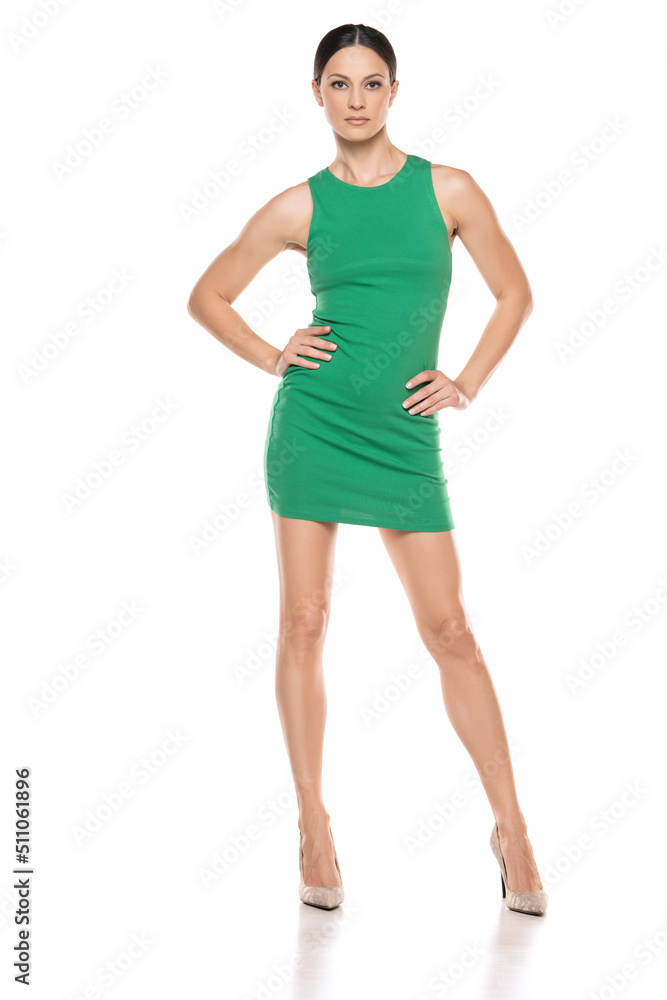 a young woman in a short green dress posing on white background a young woman in a short green dress posing on white background