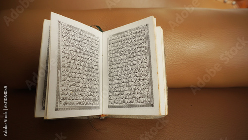 An open page of Quran. Quran is an Islamic Holy Book for all muslims. Selective focus. photo